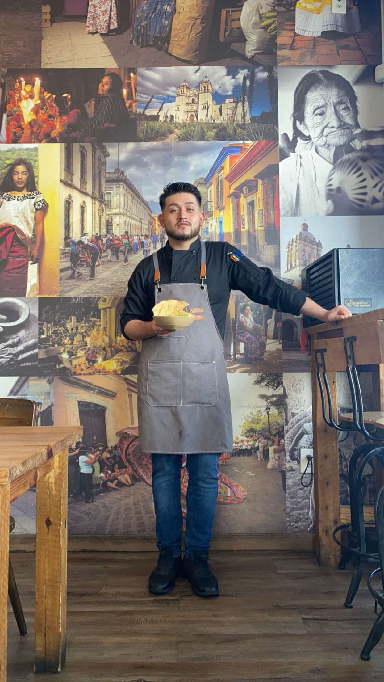 Chef Arturo Hernández in an apron holding a plate